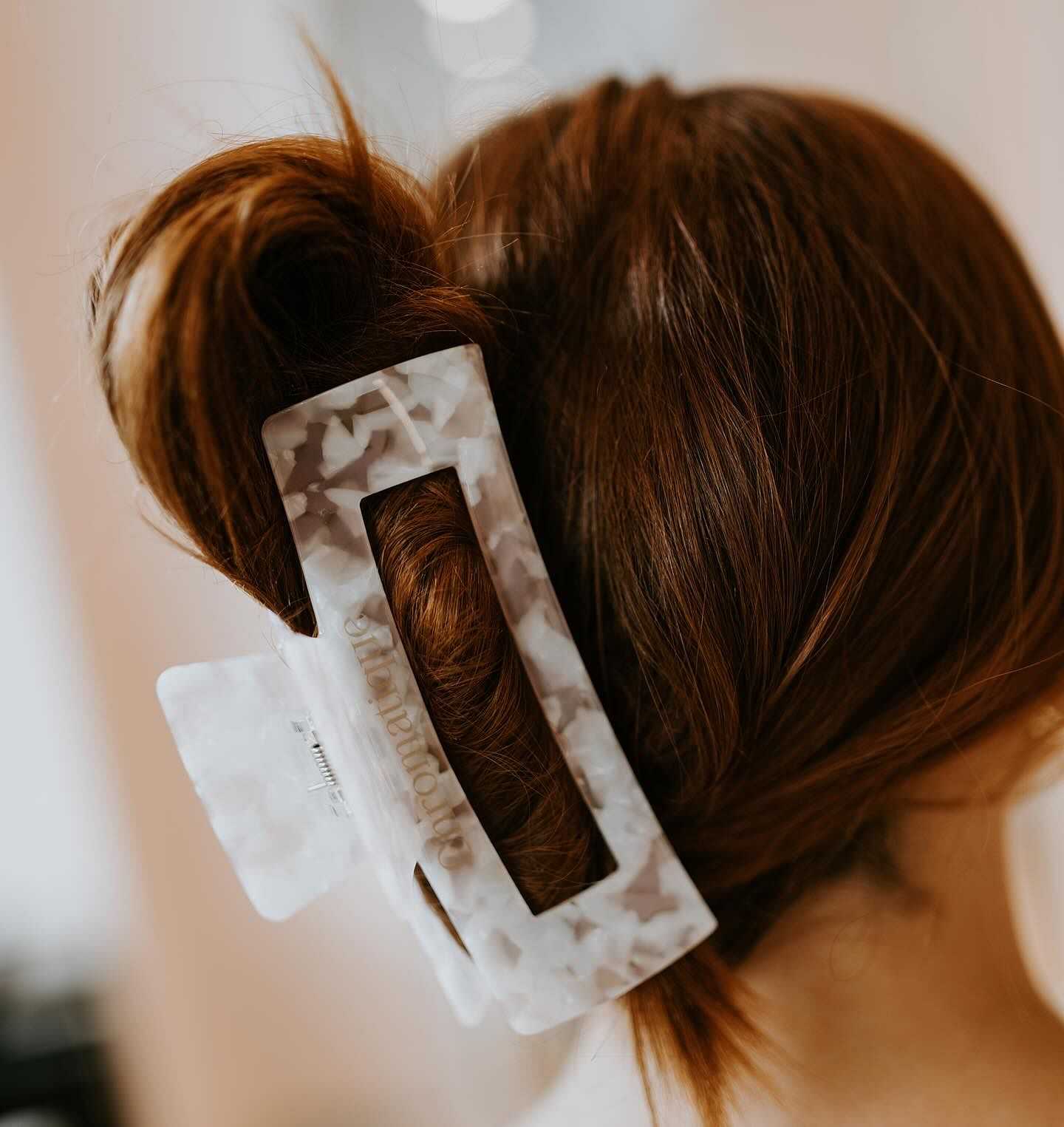 Hair styled in a bun using a large white claw clip.