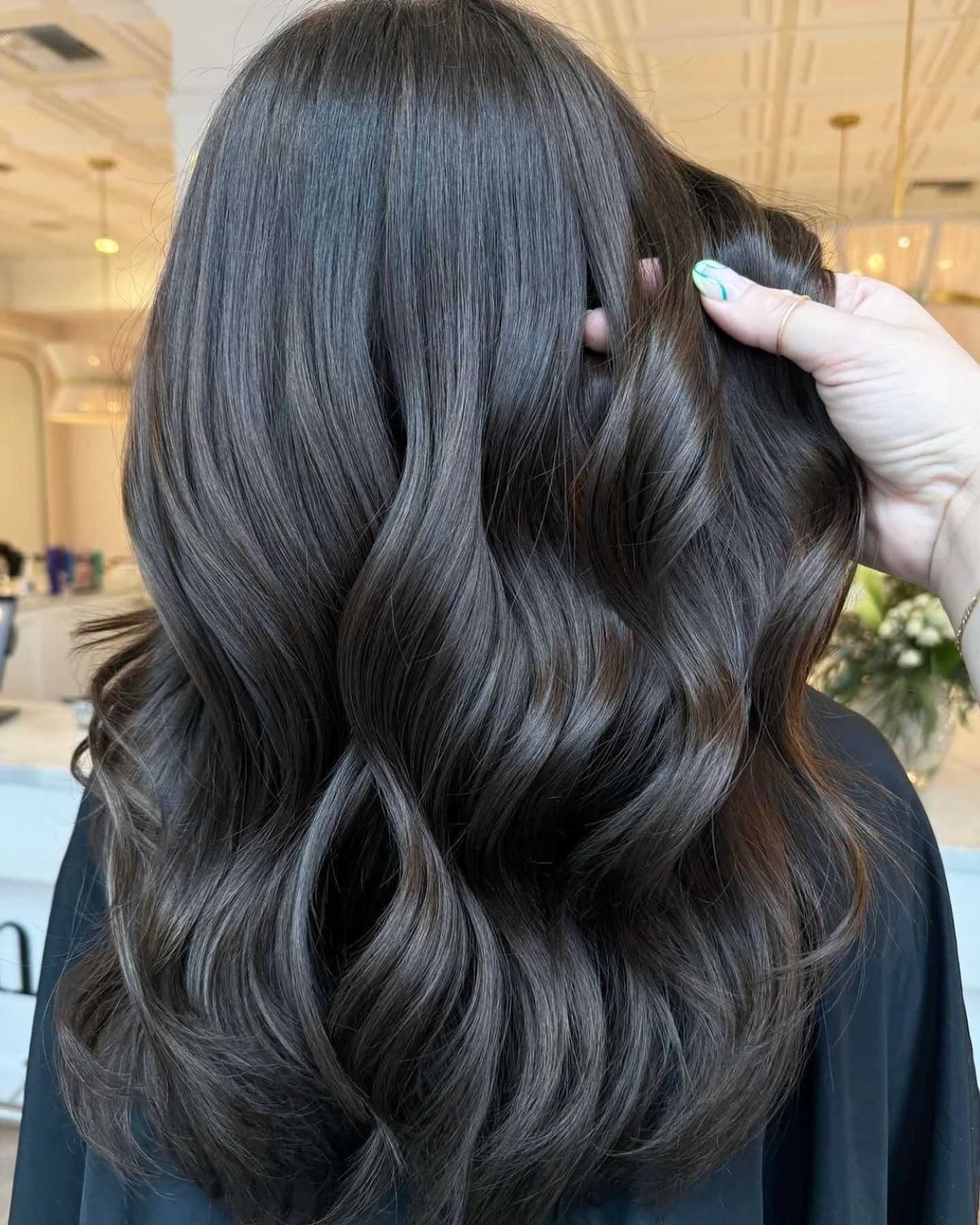 Smooth, wavy brown hair styled in a luxurious salon setting.